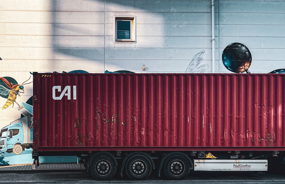 a red cargo truck parked in front of a building