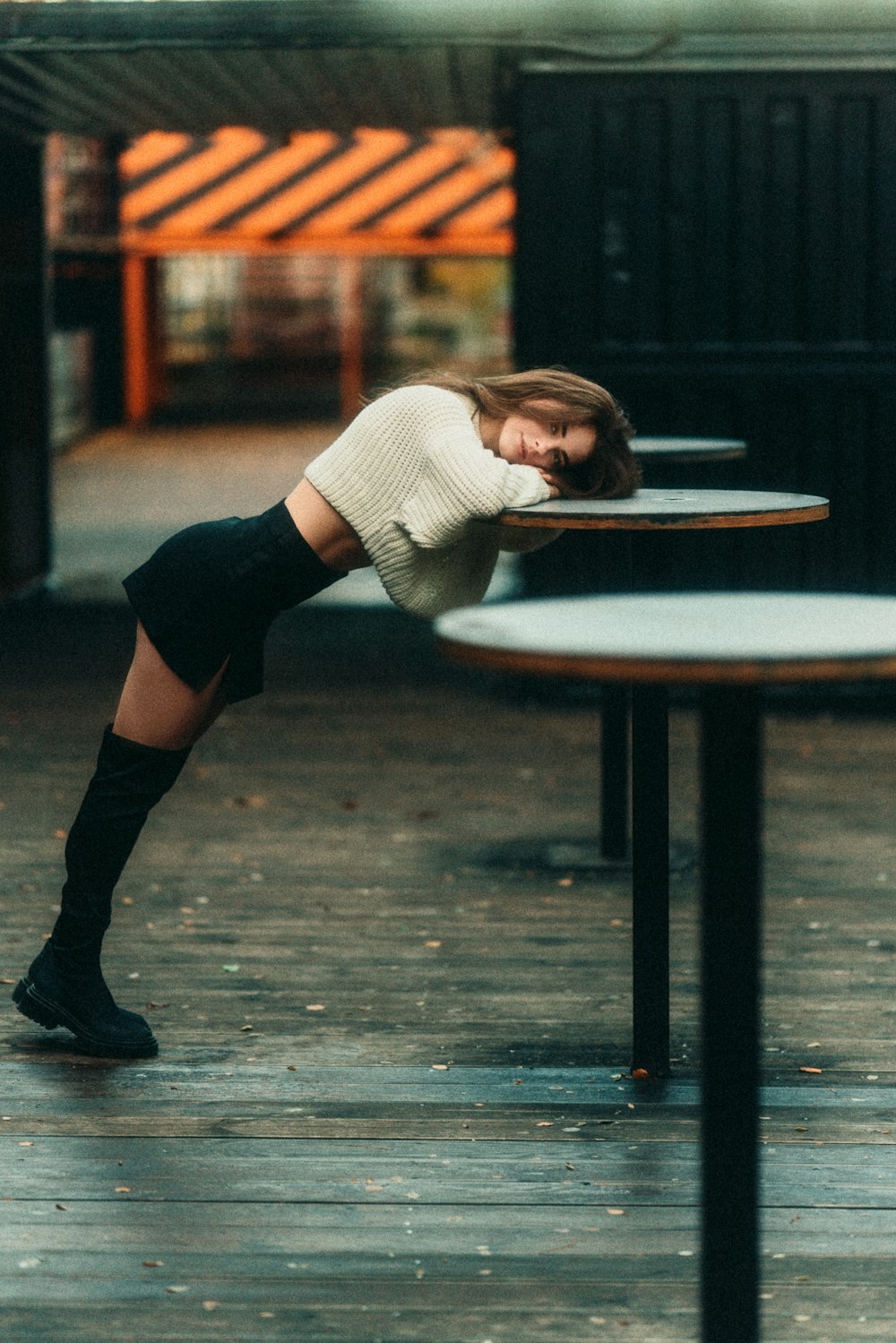 a woman leaning on a table with her head on her knees