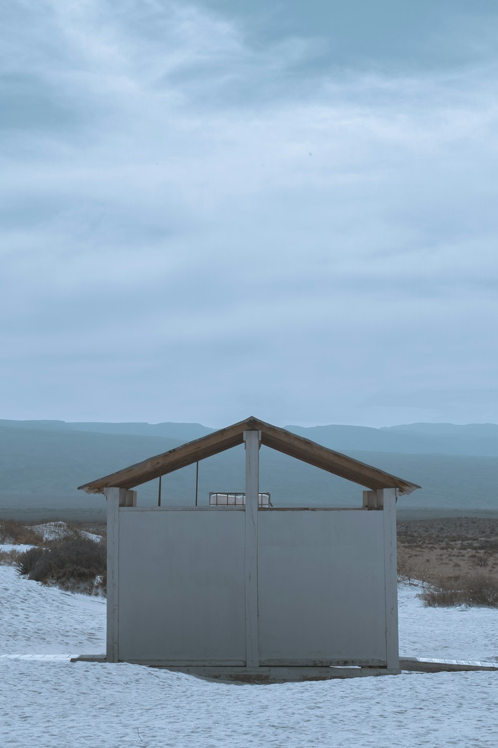 a small building in the middle of a snowy field