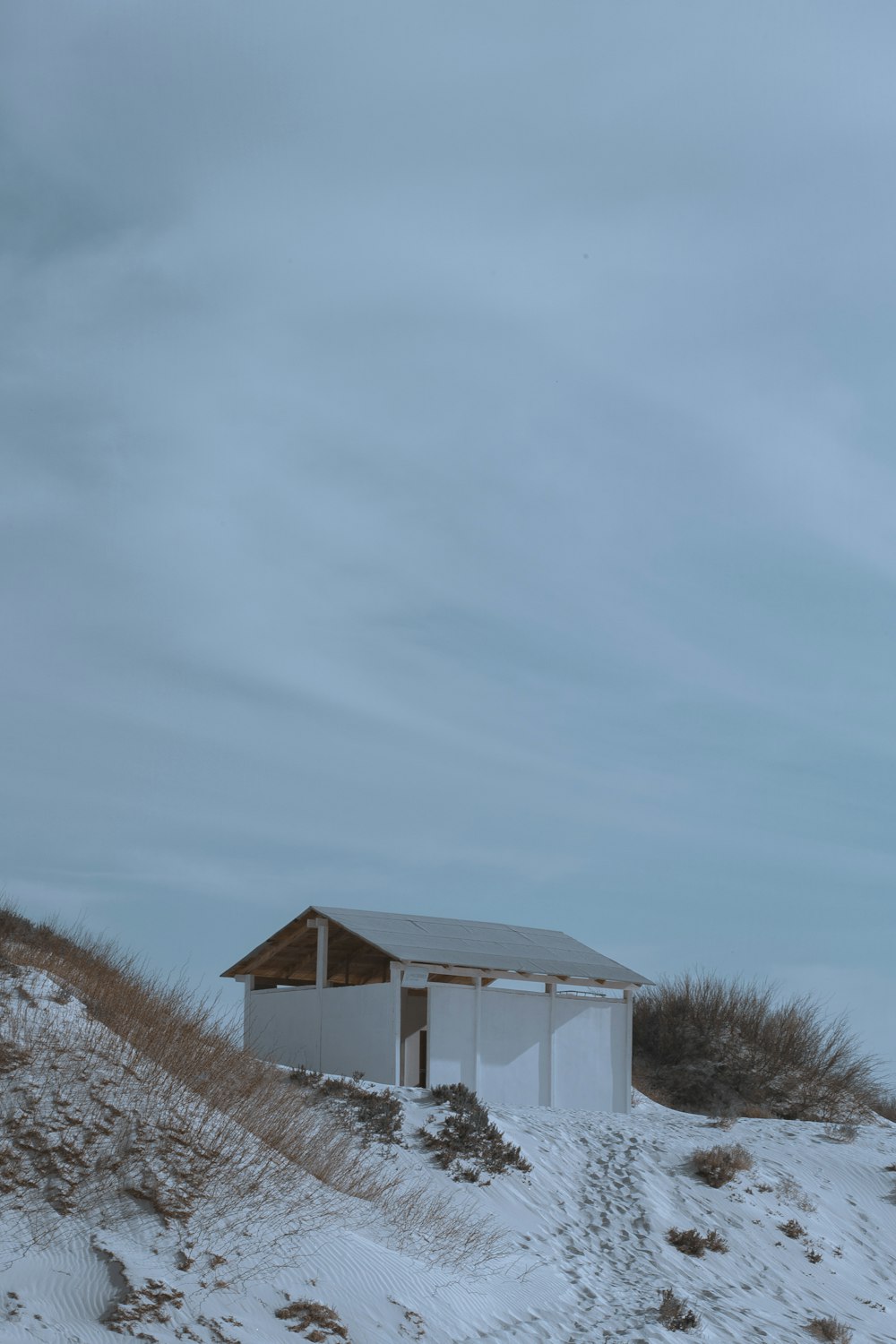 a white building sitting on top of a snow covered hill