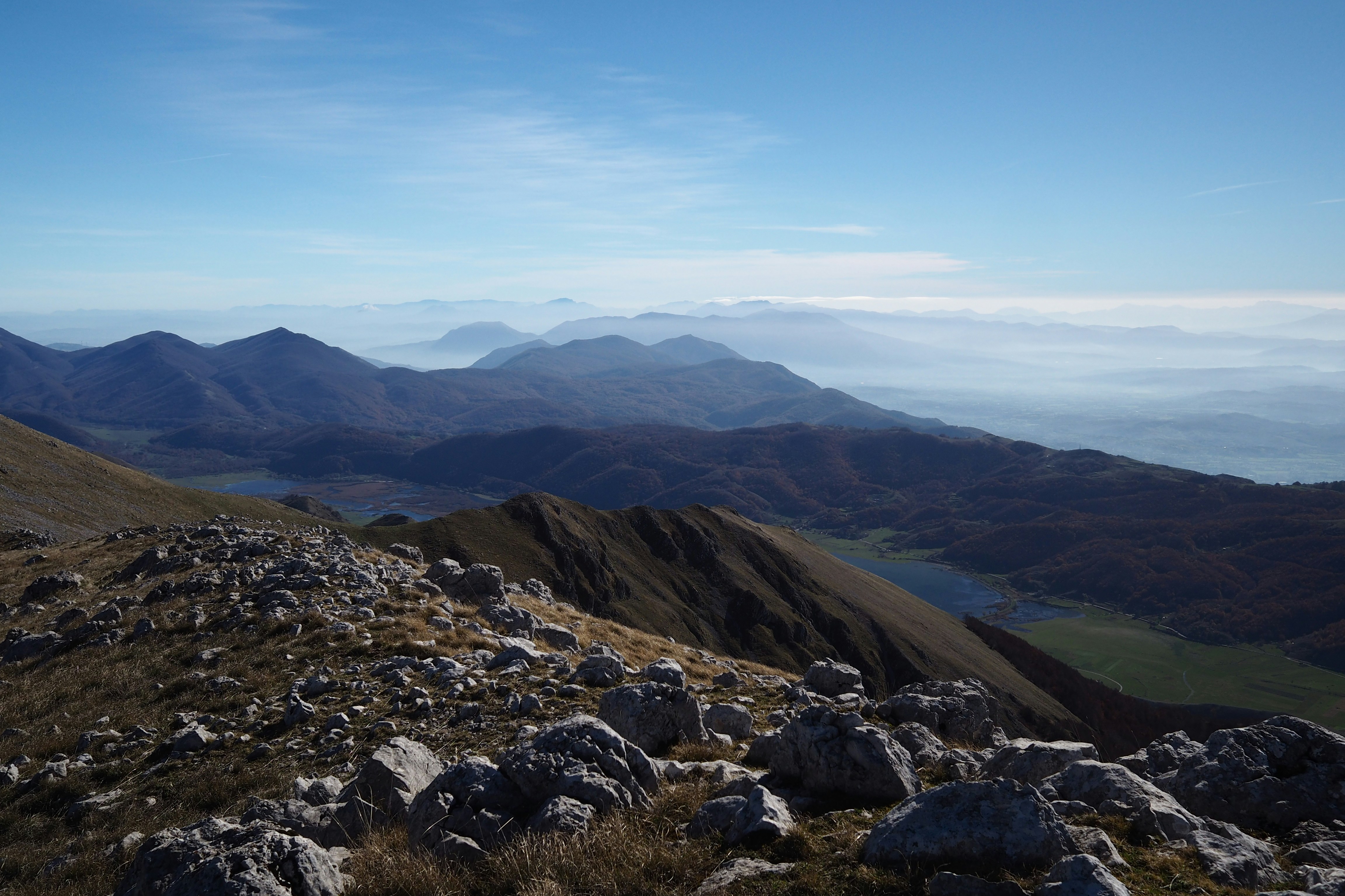 Una vista di una catena montuosa con un lago in lontananza