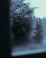 Snowflakes gently falling over a city bench where winter wear donations are neatly stacked.
