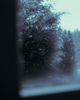 Snowflakes gently falling over a sleek, modern HVAC system in a bright room.