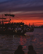 A vibrant cruise ship sailing under a golden sunset with happy travelers on deck.