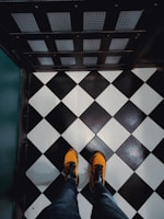 A pair of stylish orange shoes on a wooden floor.