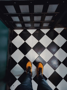 A pair of stylish orange shoes on a wooden floor.