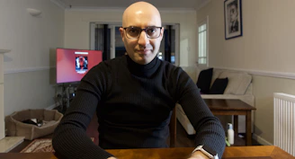 Friendly technician explaining maintenance details to a homeowner inside a cozy living room.