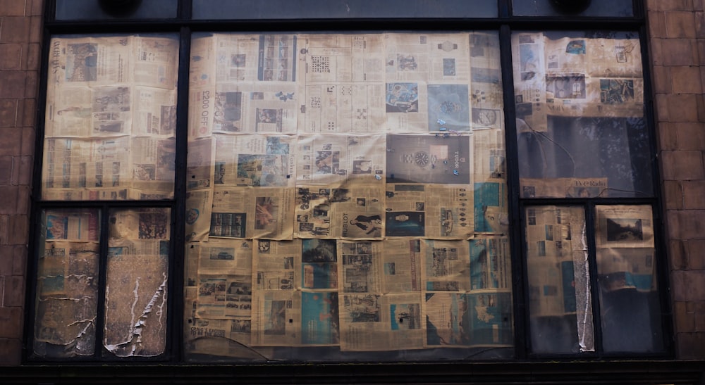 a window with a bunch of newspapers on it