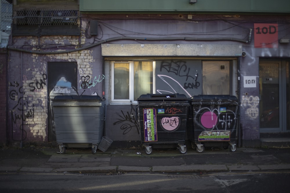 a couple of trash cans sitting on the side of a road