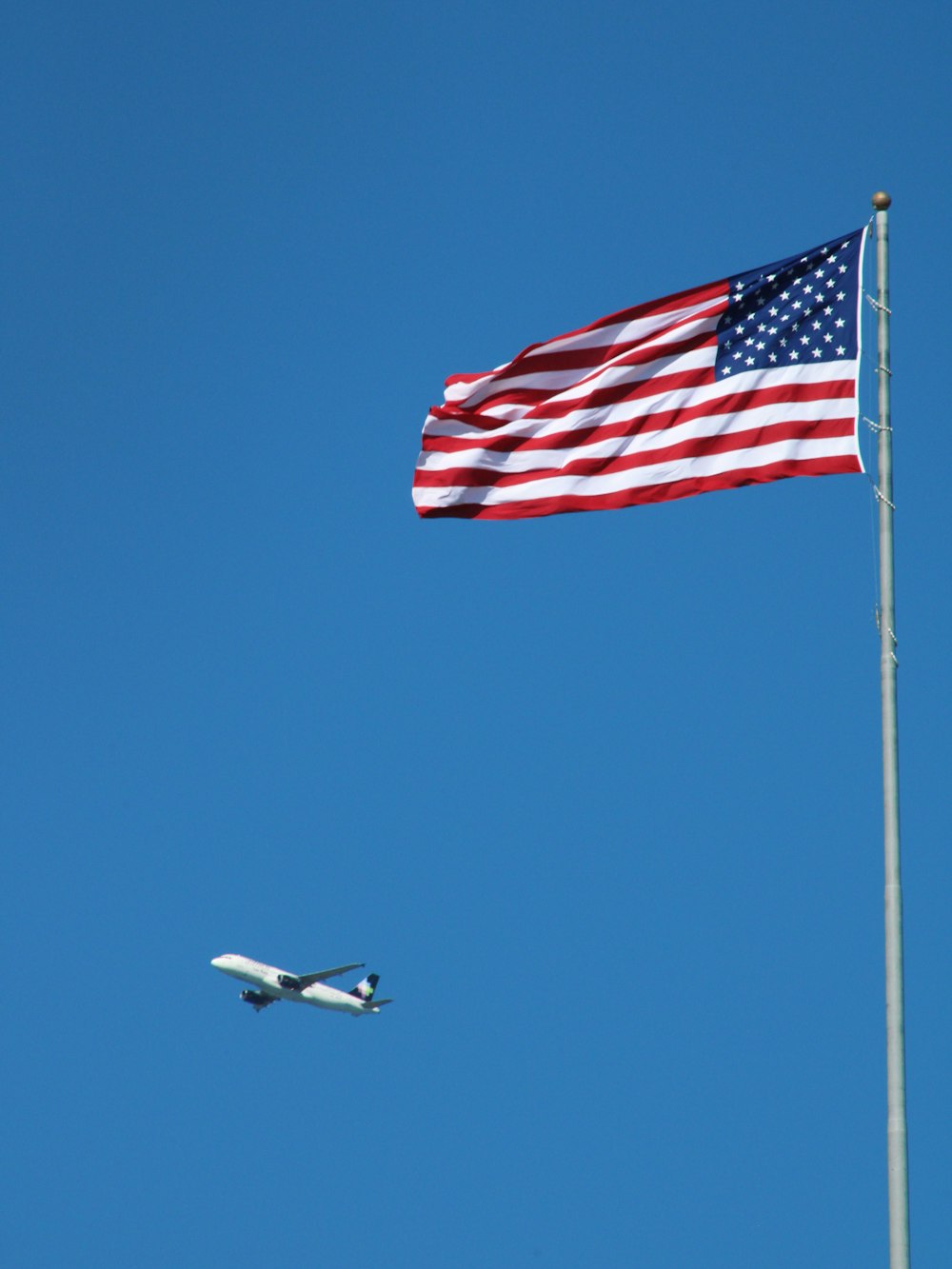 Un drapeau américain et un avion volant dans le ciel