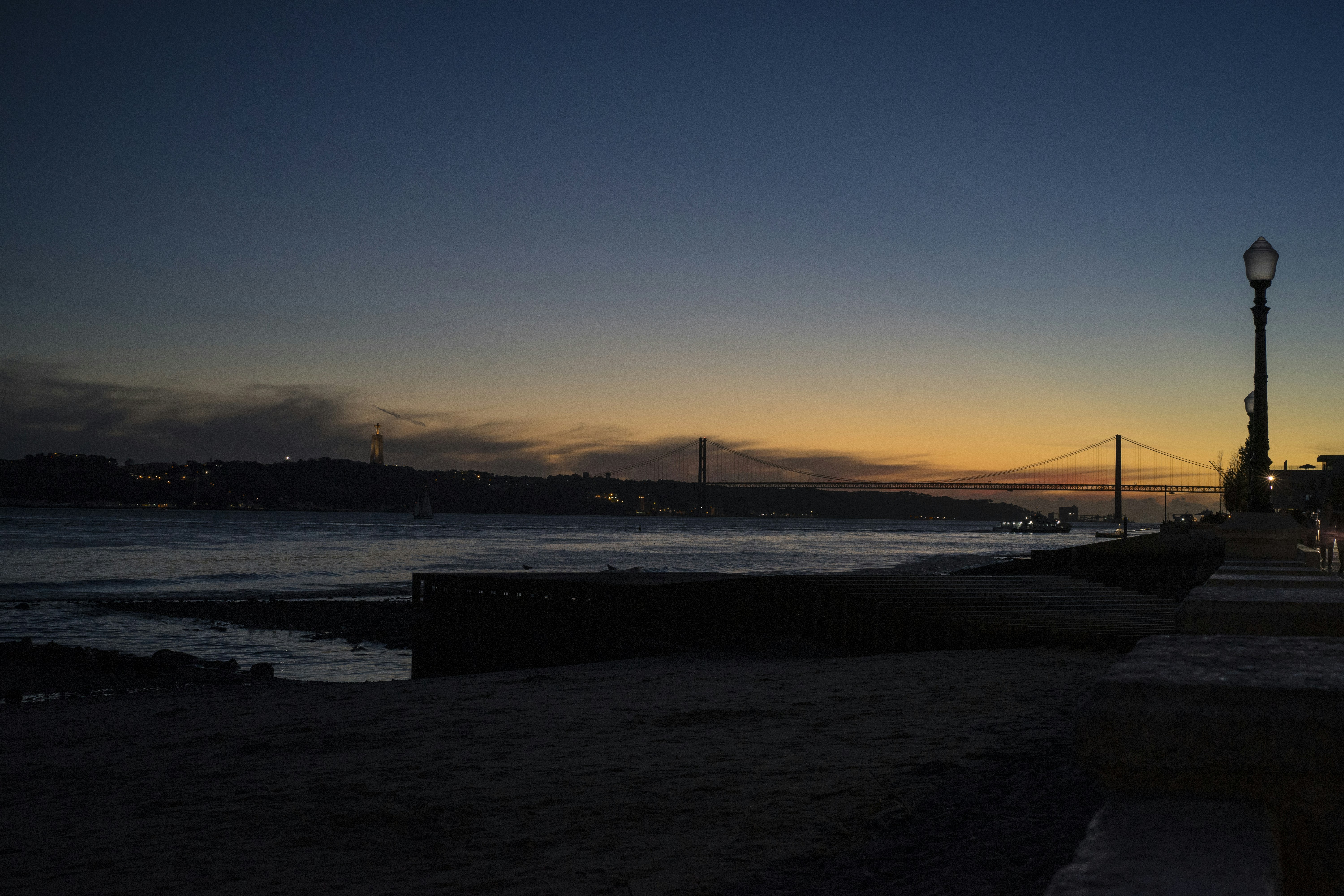 the sun is setting over the water at the beach, 