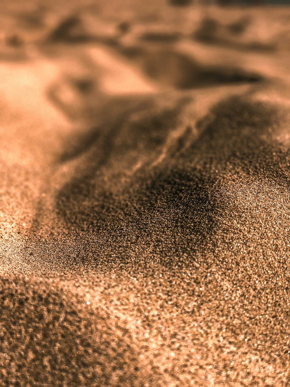 a close up of sand with a blurry background