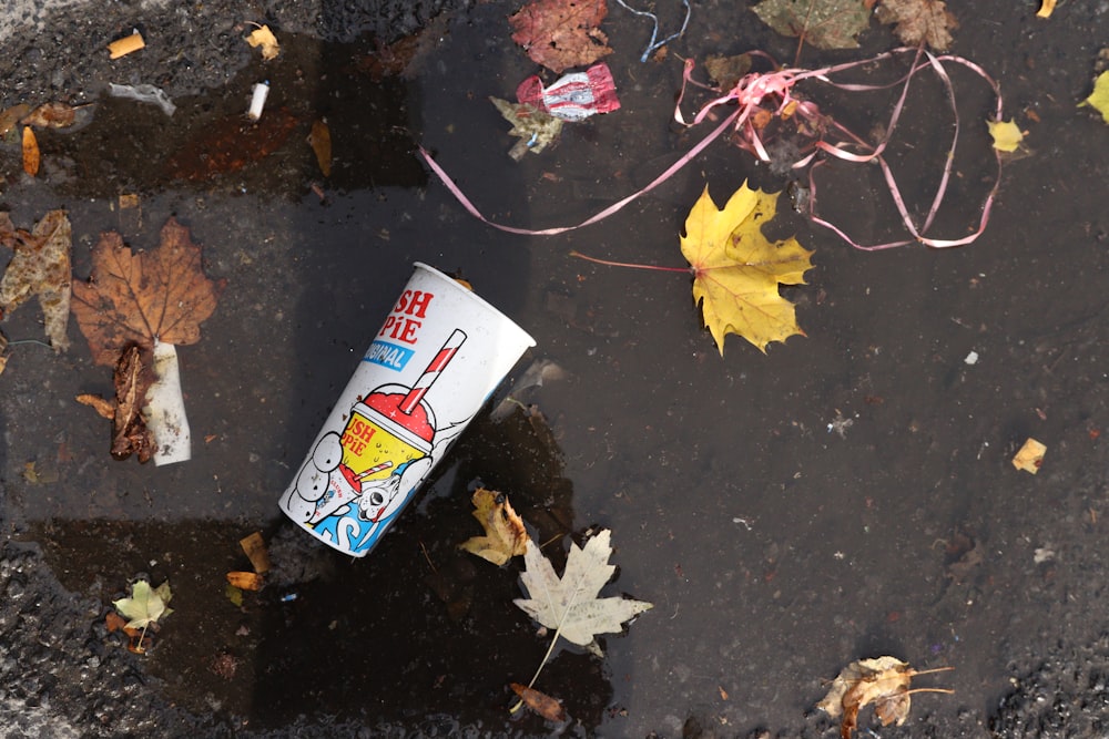 a can of ketchup sitting on top of a puddle of water