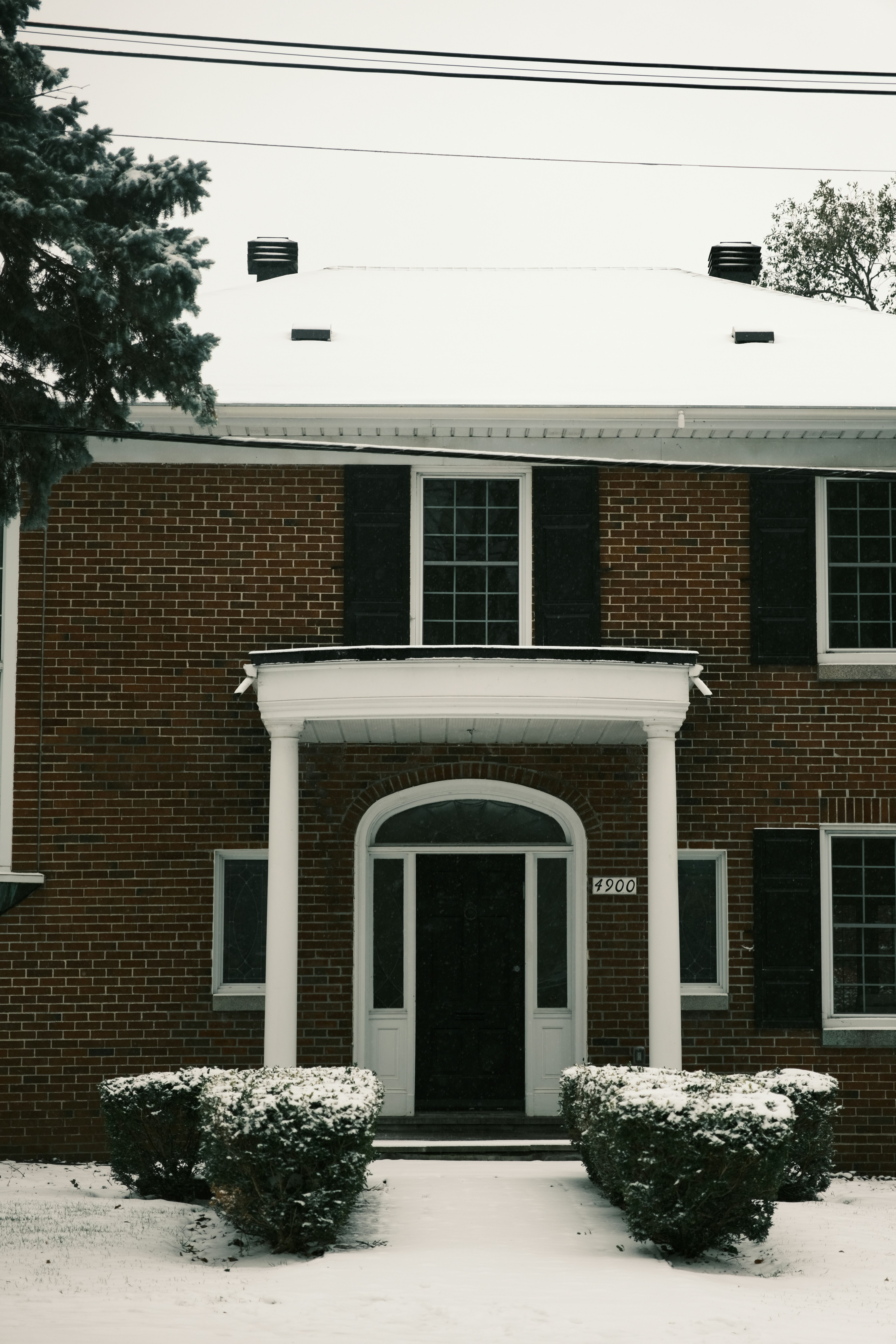 a red brick building with a white door and black shutters