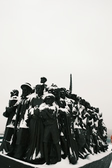 a group of people standing around a statue covered in snow