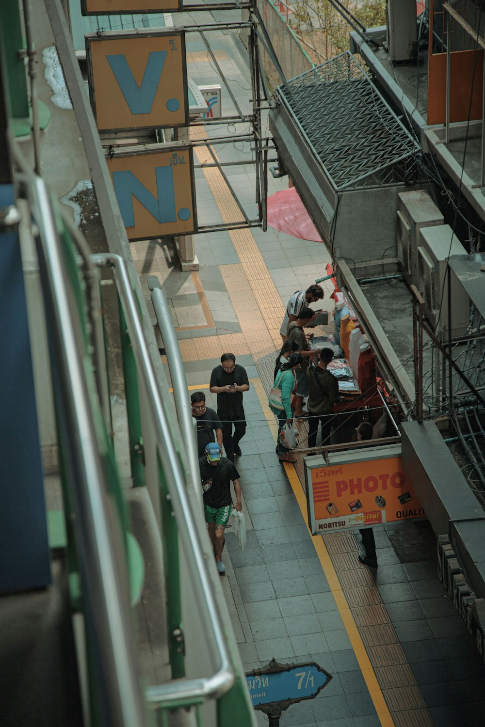 a group of people walking down a walkway next to a train