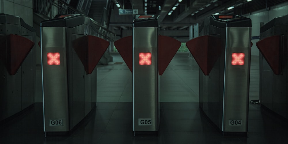 a row of metal stalls with red crosses on them