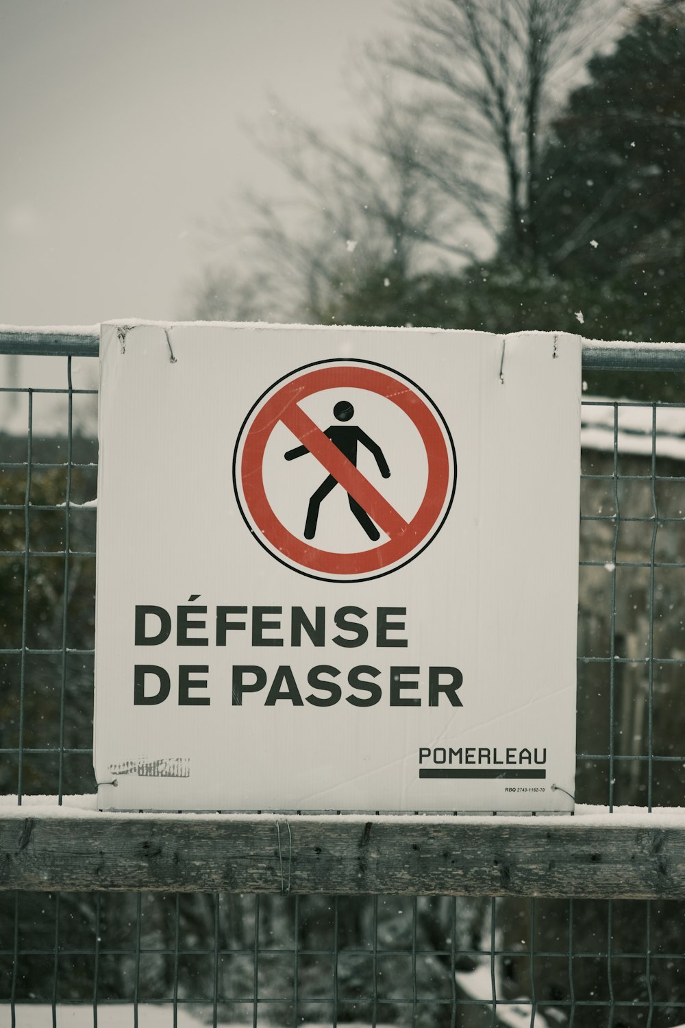 a sign that is on a fence in the snow