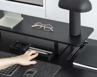 A sleek office desk setup with a minimalist lamp, ergonomic chair, and neatly organized smart office accessories.