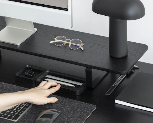 A sleek, modern office desk setup with ergonomic accessories and stylish lighting.