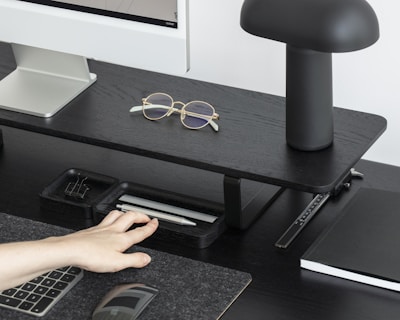 An adjustable office desk setup with a sleek laptop and organized workspace.