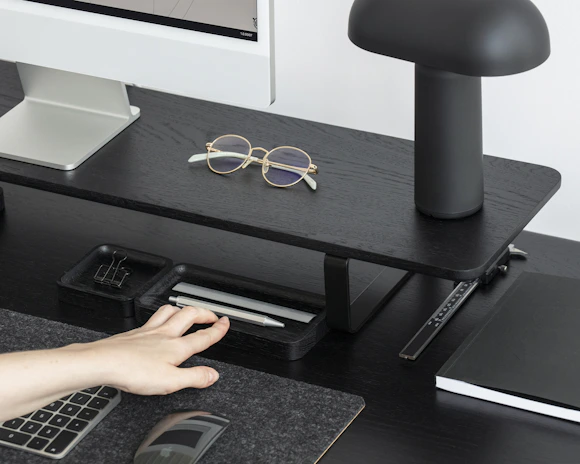 A neat office desk setup featuring a sleek printer and organized paperwork.