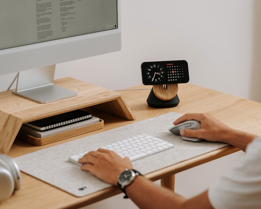 a person sitting at a desk with a mouse and keyboard