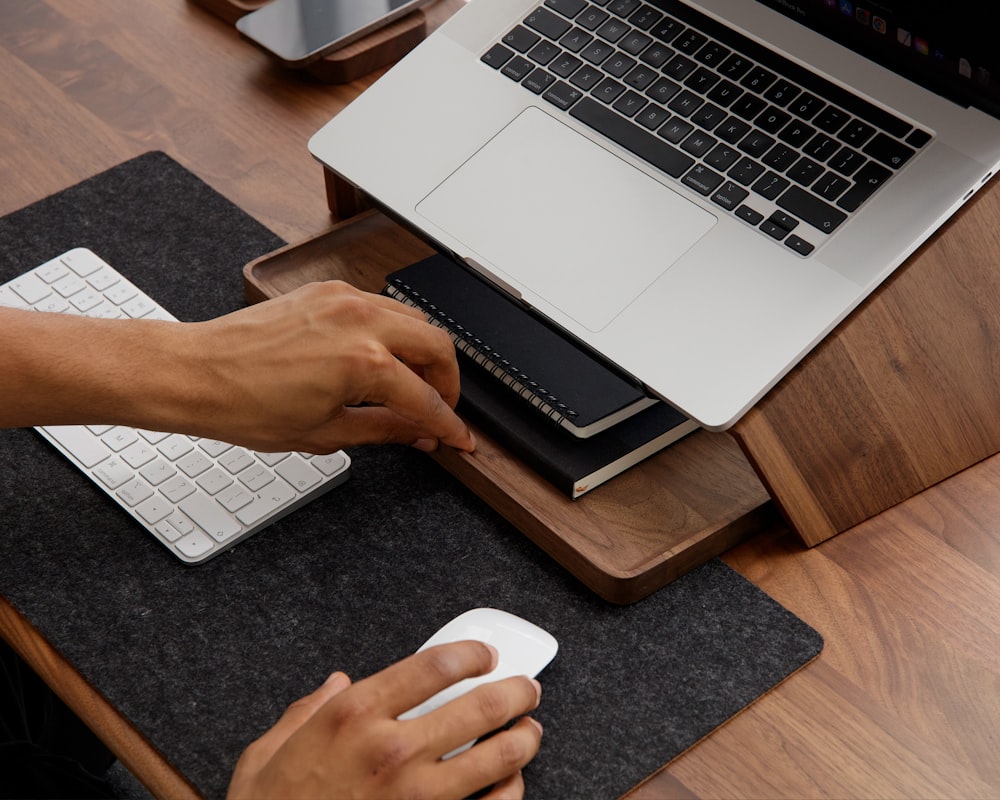 a person sitting at a desk with a mouse and keyboard