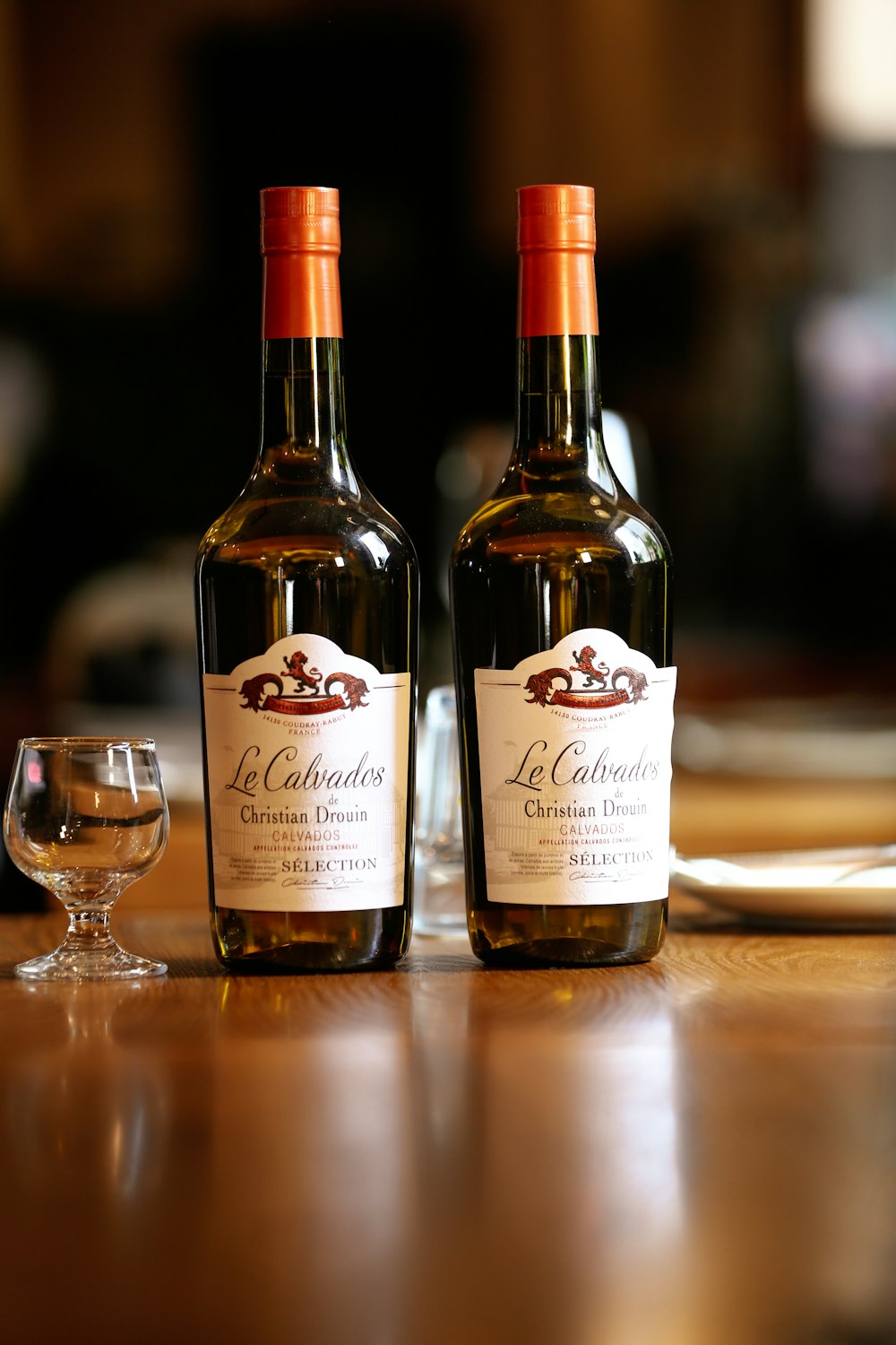 two bottles of wine sitting on top of a wooden table