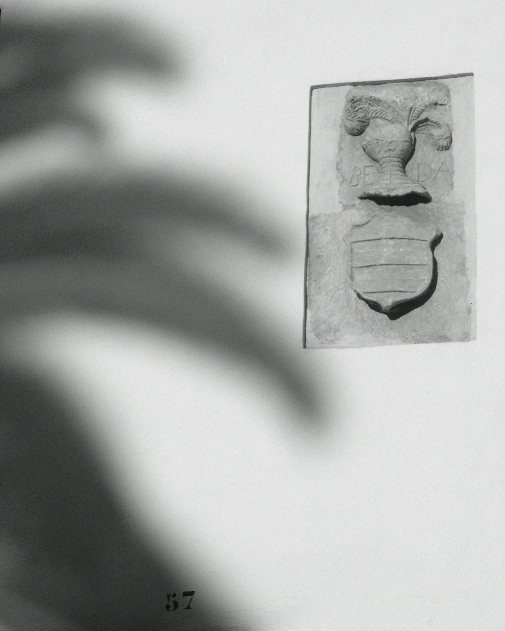 a black and white photo of a sculpture on a wall