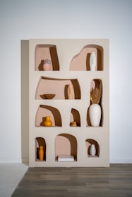 An artful display of layered textiles and sculptural ceramics arranged on a minimalist shelf.