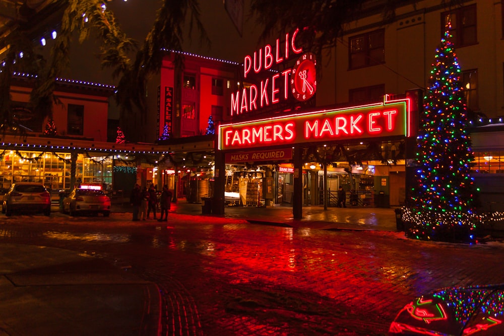 a christmas tree is lit up in front of a market