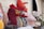 A collection of colorful, handmade stuffed animal toys is arranged in a line. The foreground features a rooster crafted from patterned fabric, displaying intricate textures and vibrant colors. Other animals, including a fox and a pig, are visible in the background, all made with similar attention to detail.