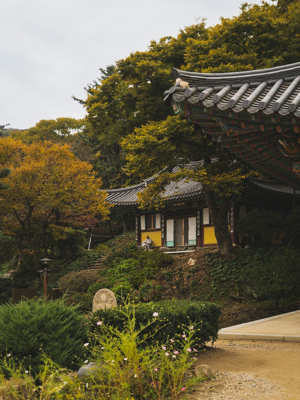 a building with a roof and a lot of trees in the background