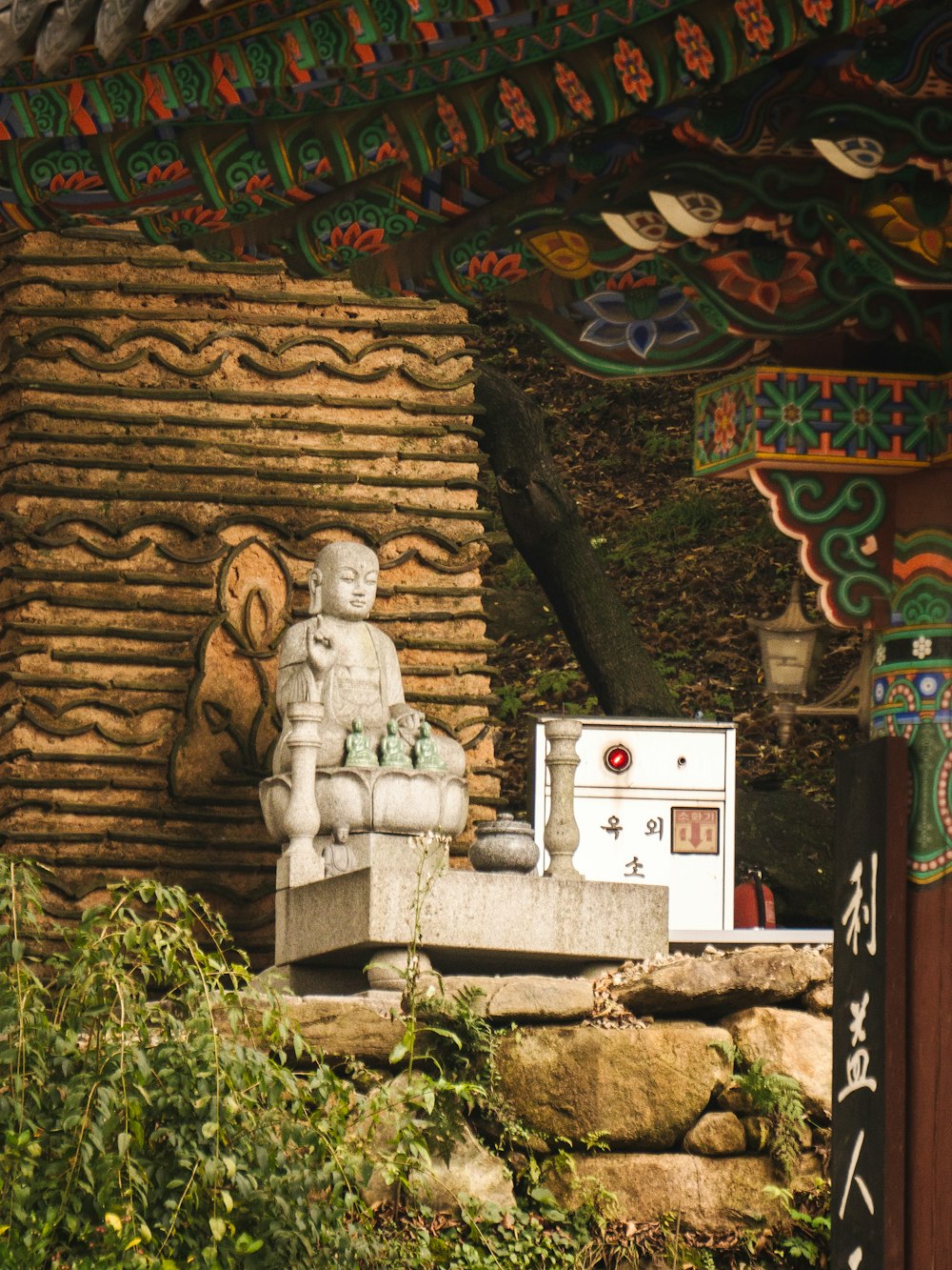 a statue of a buddha sitting on top of a stone bench