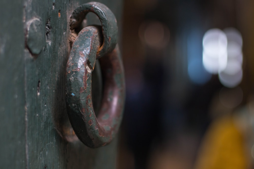 a close up of a door handle on a green door