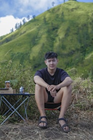 a man sitting on a chair in front of a mountain