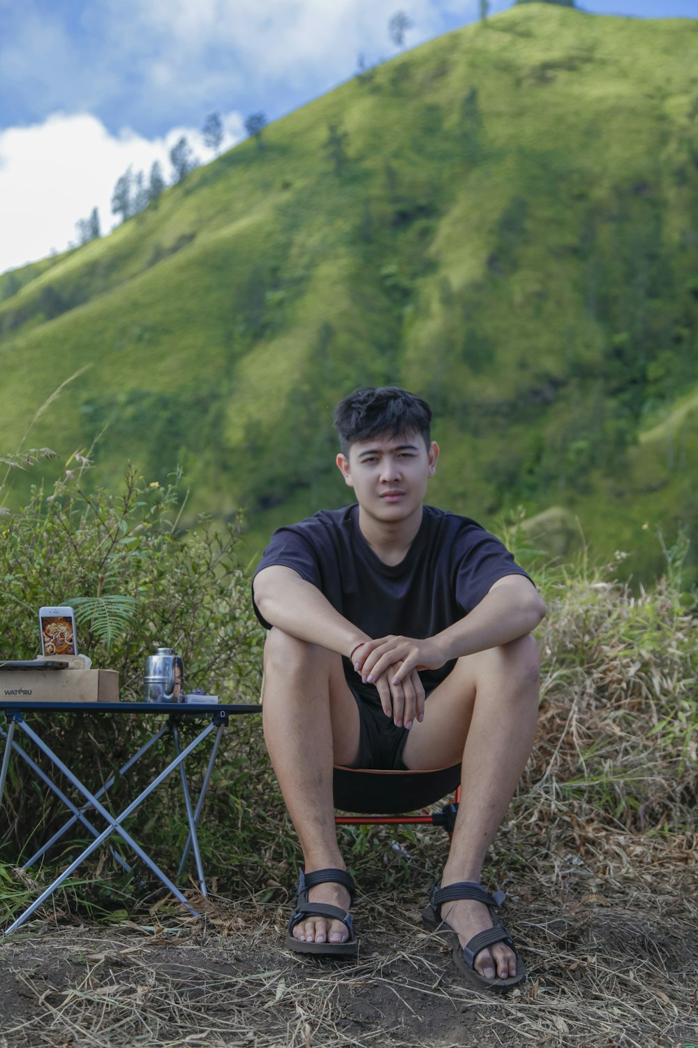 a man sitting on a chair in front of a mountain