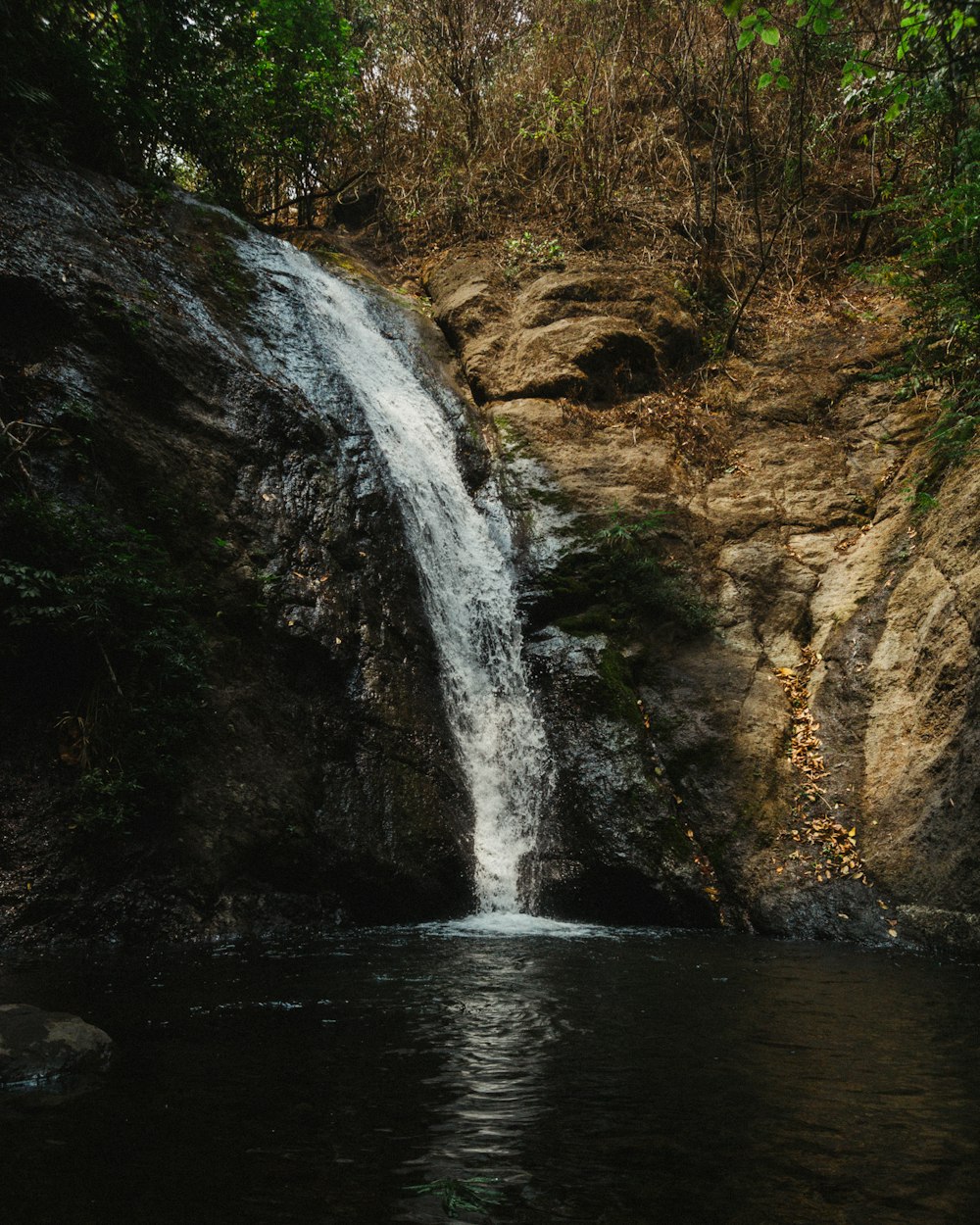 a small waterfall in the middle of a body of water