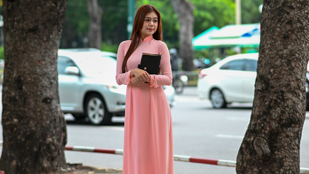 a woman in a pink dress holding a bible