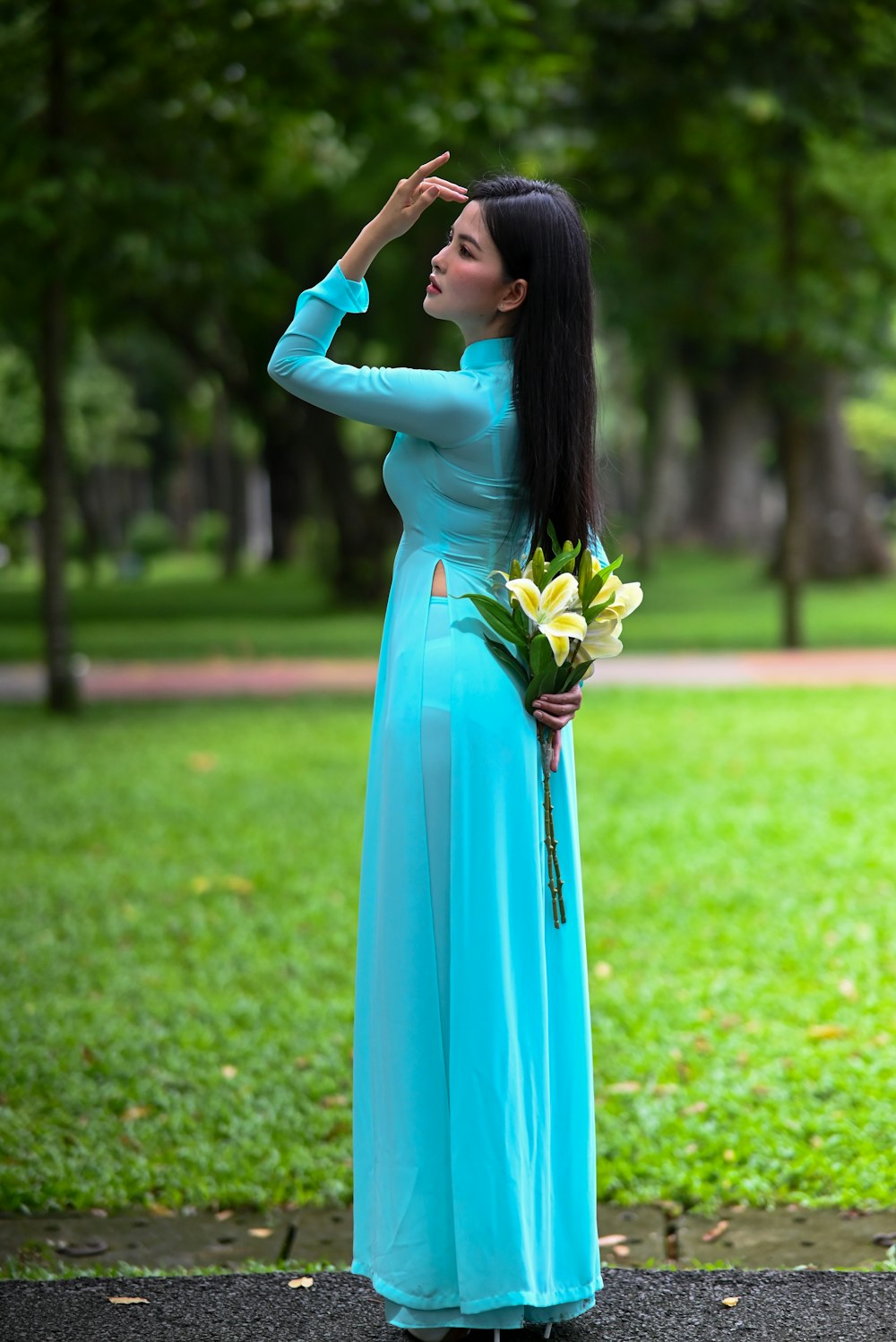 a woman in a blue dress holding a bouquet of flowers