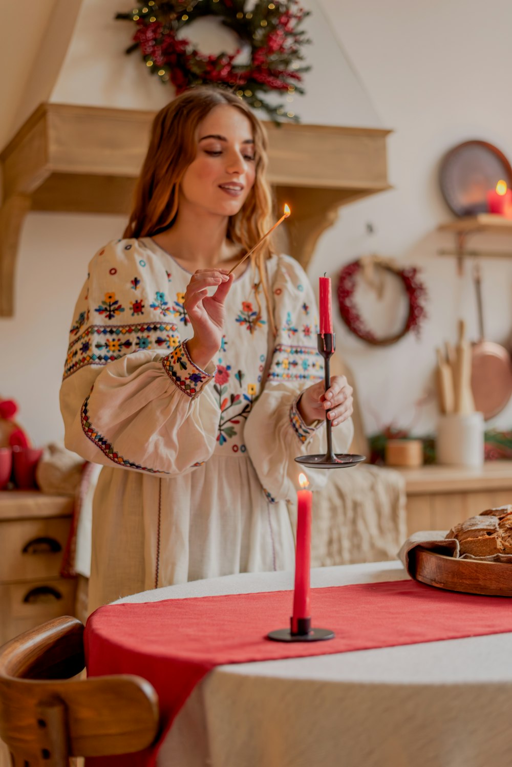 a woman holding a lit candle at a table