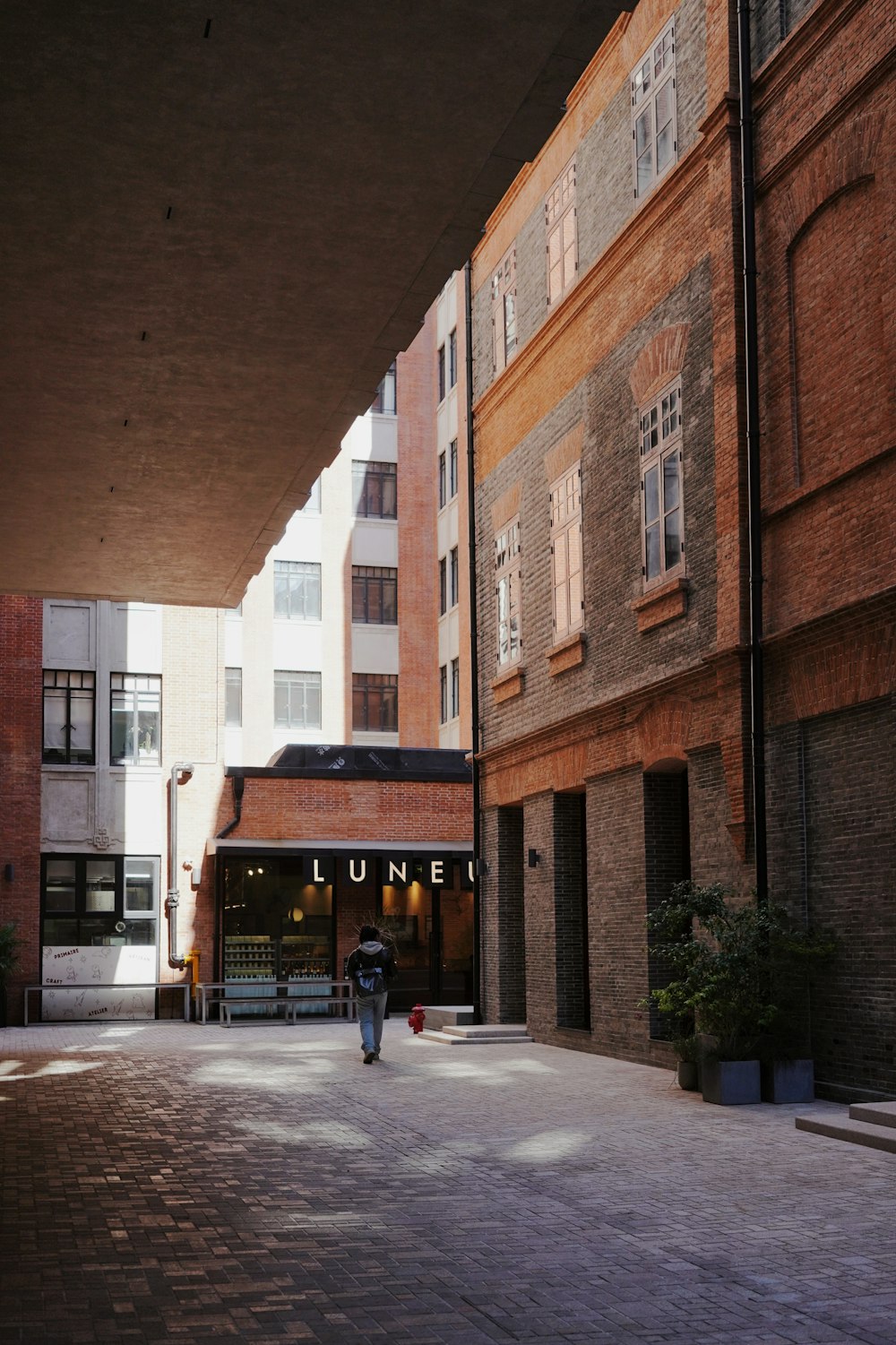 a person walking down a street next to tall buildings