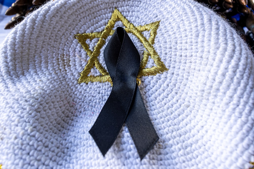 a black ribbon on a white cloth with a star of david on it
