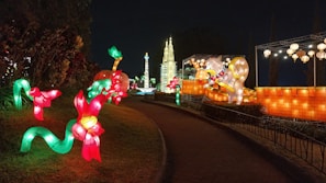 Evening scene with glowing lanterns and floral installations lighting up the festival grounds