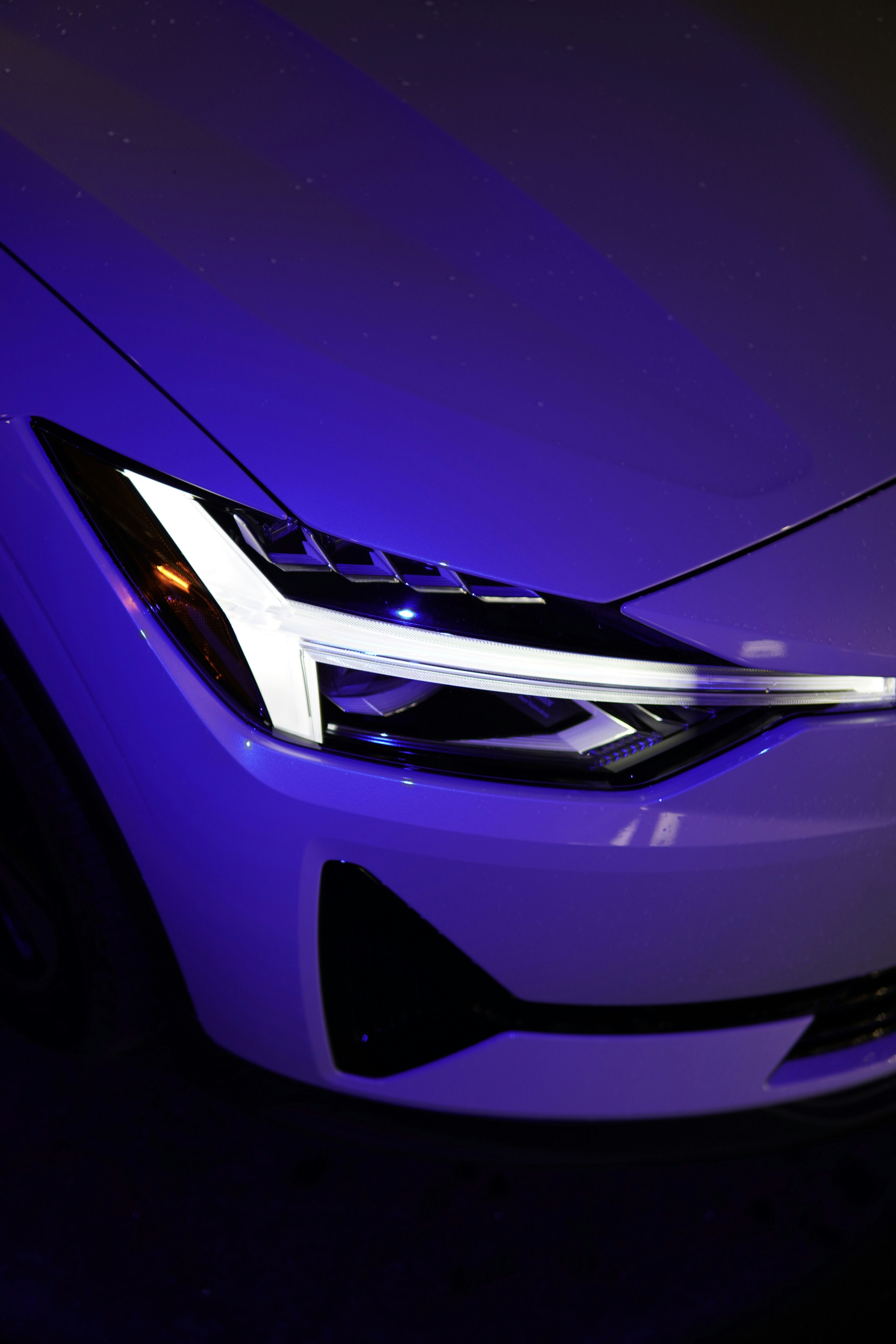 a close up of a car's headlight on a dark background