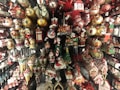 A variety of colorful Christmas ornaments and decorations arranged on shelves, including Santa figurines, nutcrackers, baubles, candy canes, mini trains, and stockings. The ornaments are in vibrant shades and depict traditional holiday themes.