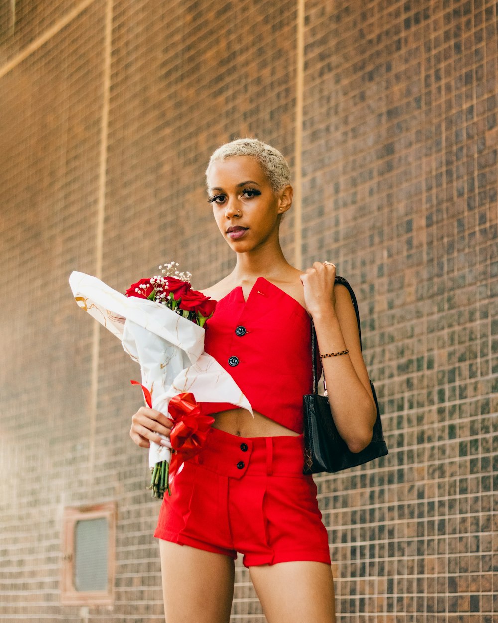 a woman in a red outfit holding a bouquet of flowers
