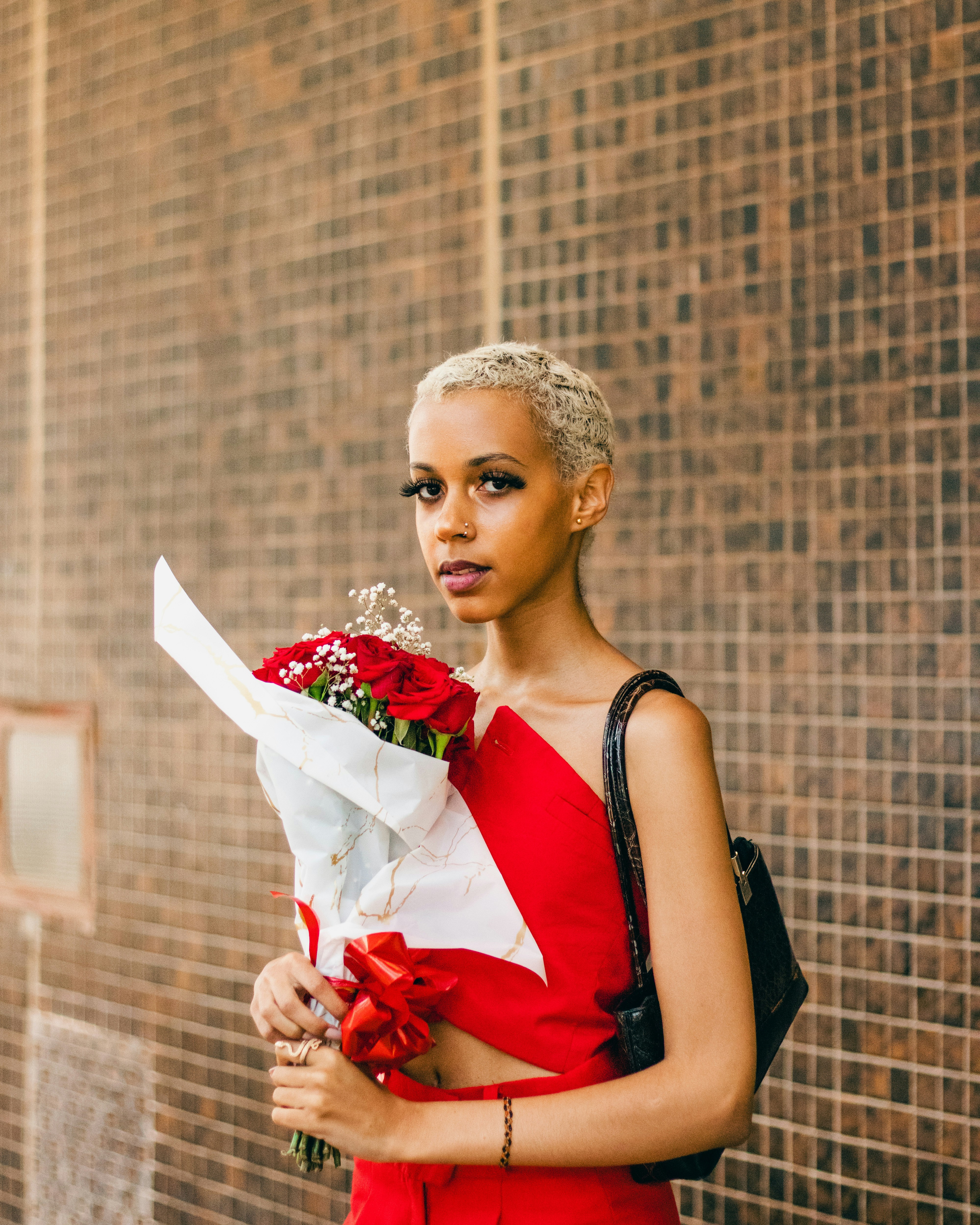 A woman in a red dress holding a bouquet of flowers photo  Free Girl Image  on Unsplash
