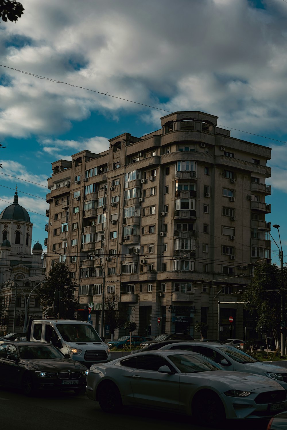 a group of cars parked in front of a tall building